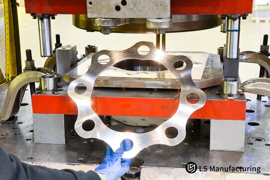 Punching multiple holes in a circular 6061 aluminum bracket for automotive mounting or linkage parts.