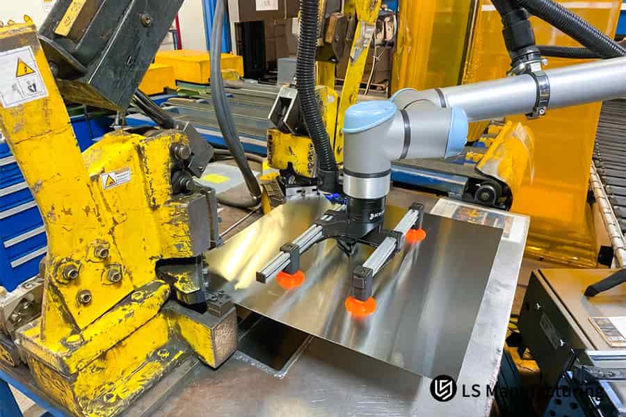 Робот размещает 304 листа нержавеющей стали на штамповочном прессе для крупносерийного производства компонентов автомобильного шасси.