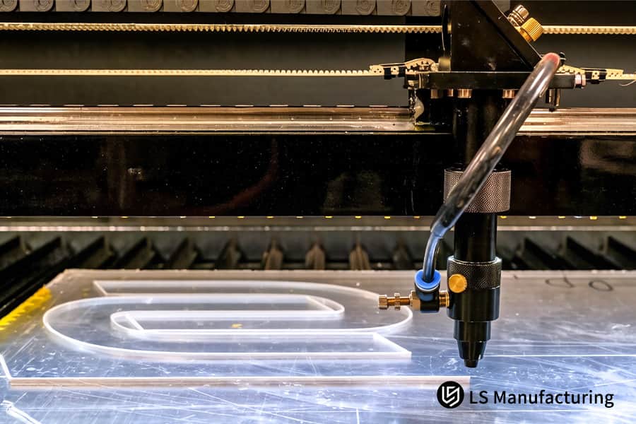 A CNC laser traces lettering on acrylic for high-precision signage using precision laser cutting services.