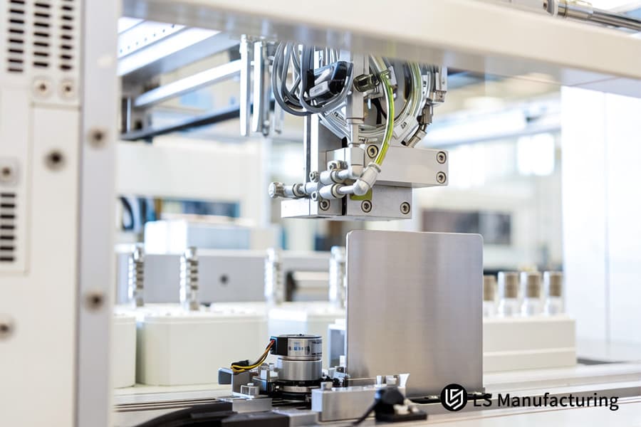 Техник обрабатывает листы нержавеющей стали 316L для линии по производству индивидуальных медицинских компонентов из листового металла.