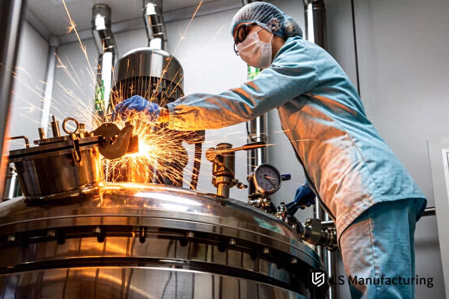 Техник шлифует края зажимов из нержавеющей стали 316L для медицинской системы из листового металла, сертифицированной по стандарту ISO 13485.