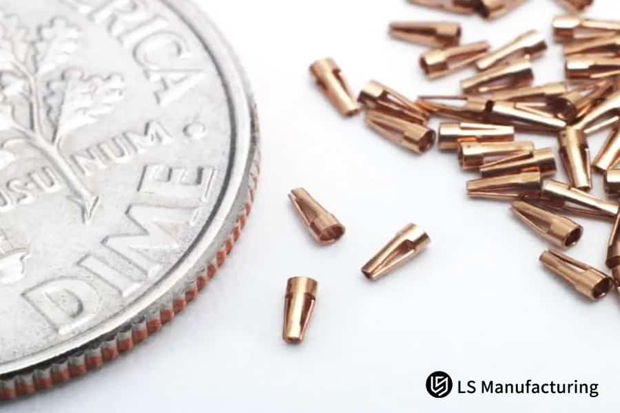 Tiny metal parts next to coin for scale.